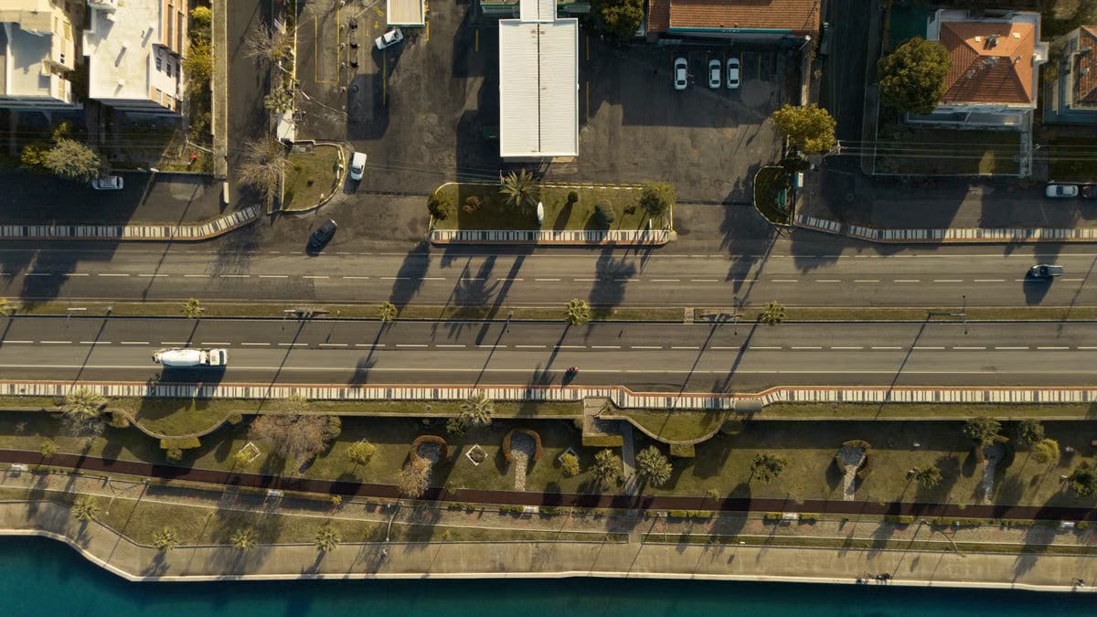 A breathtaking aerial view of İzmir's coastal road and waterfront, basking in the golden glow of sunset.